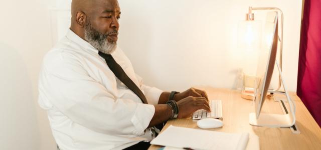 black man concerned viewing his computer 